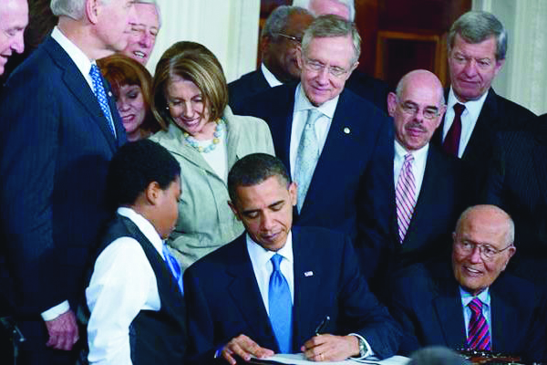 President Obama signs healthcare reform in 2010 // Credit: Reid.senate.gov